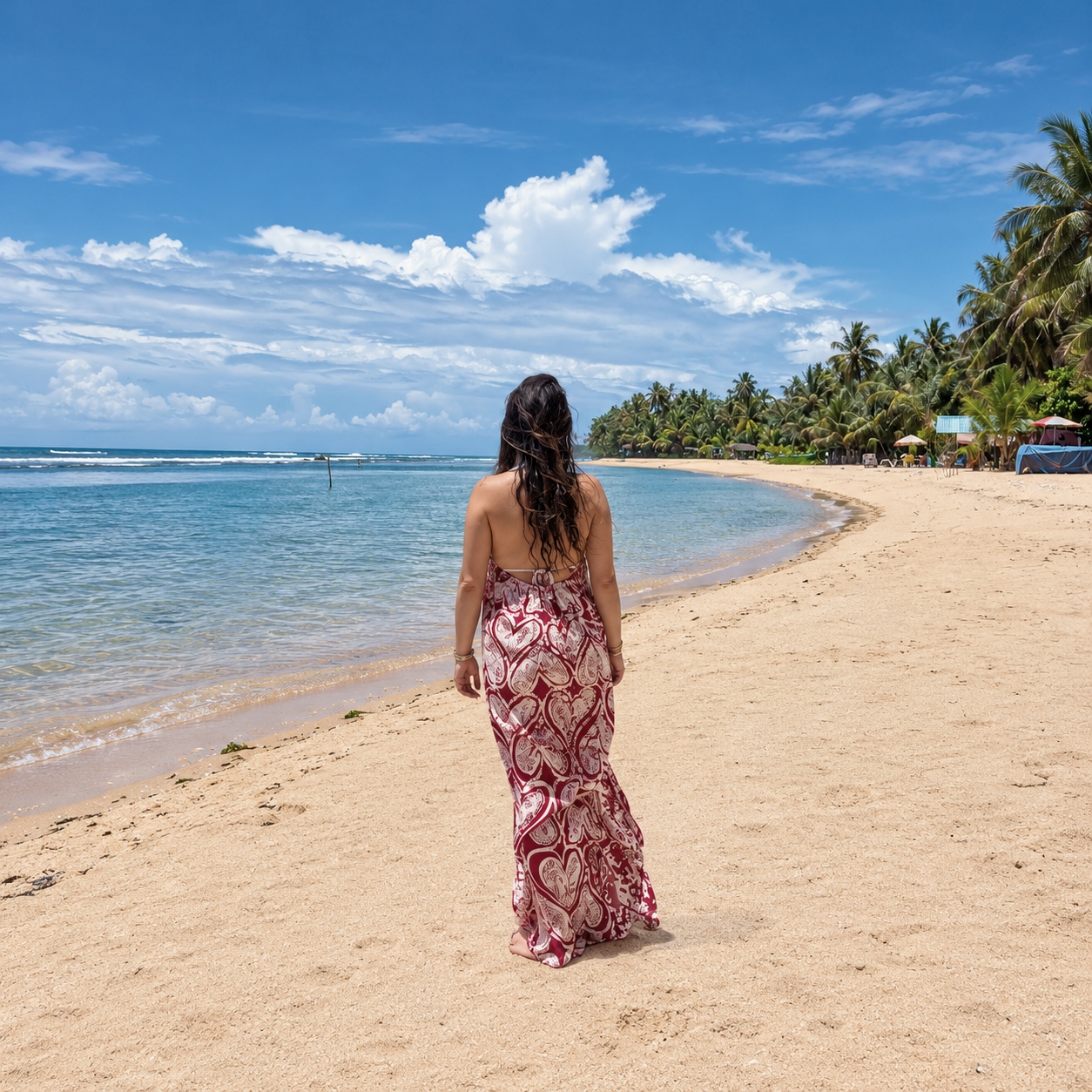 Back view of the Adire Hearts Dress showing the backless halter with drawstring ties, in rich red batik with white heart motifs