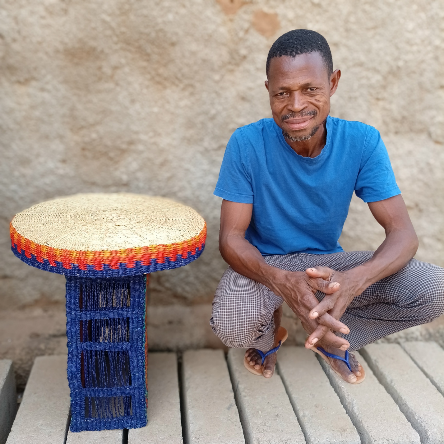 Ghanaian artisan beside the finished Amira table