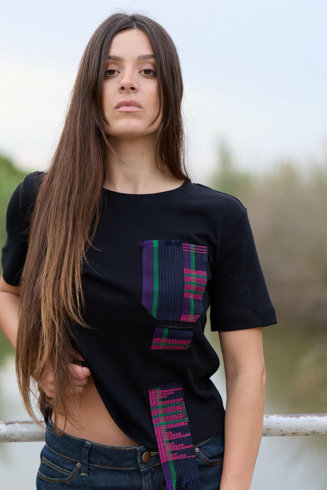 Close-up of the Asooke Urban Tee showing the handwoven pink, green and black Asooke strip on the front