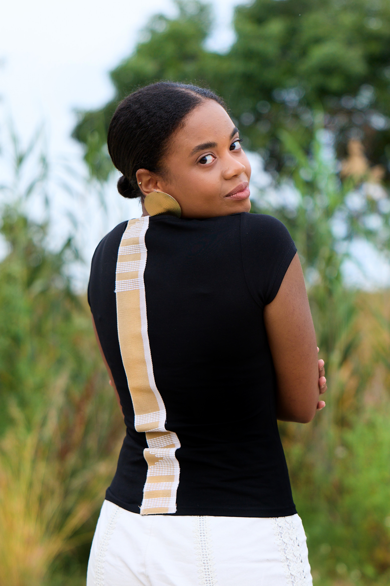 Midnight Loom Tee — close-up of the back showing the handwoven beige and white Asooke strip running top to bottom on a black cotton slim-fit t-shirt
